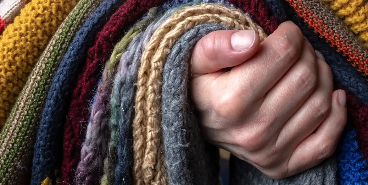 hand-holding-colorful-knitted-wool-material-textur
