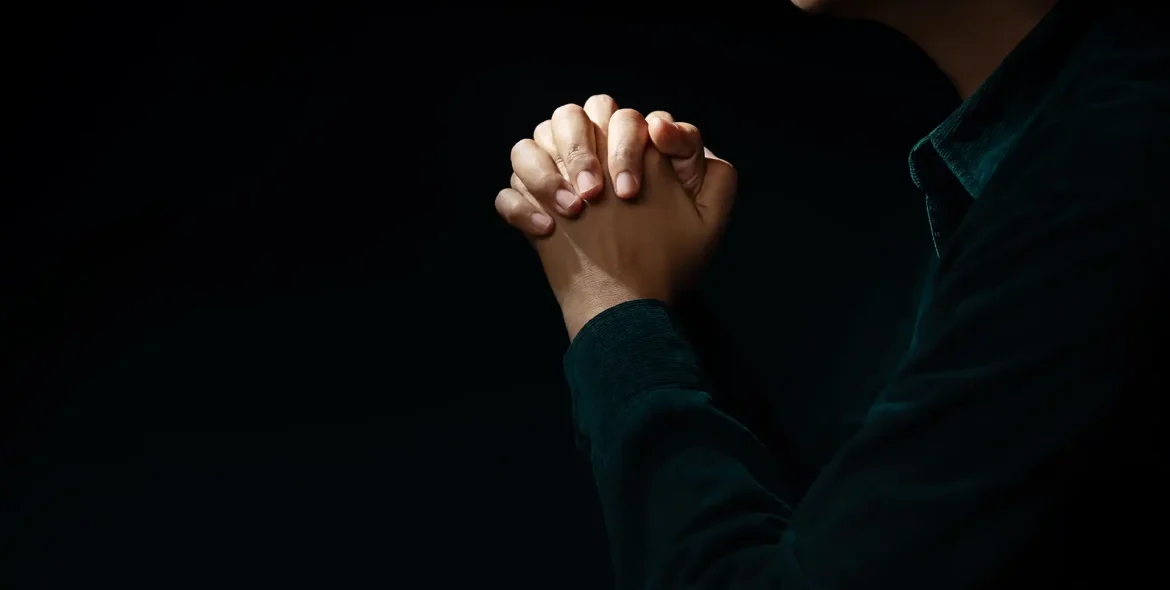 hands-clasped-in-prayerful-thought-on-dark-background